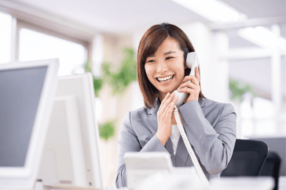 コールトラッキングにより電話応対品質の向上を実現できる受付女性の電話対応中のイメージ写真